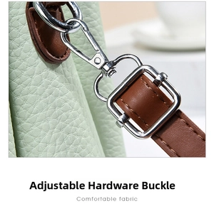 Detail of silver swivel clasp and brown leather strap on light green pebble grain bag