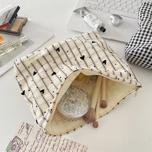 Détail de la trousse à maquillage avec motif cœur, fermeture éclair et rangement