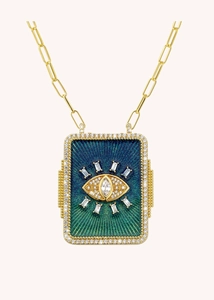 Macro detail of gold paperclip chain necklace with sparkling diamond evil eye pendant