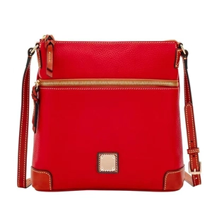 Close-up of red pebbled leather crossbody bag with brown trim and gold hardware details