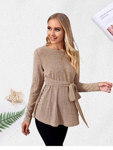 Detail of tan ribbed knit maternity sweater featuring a matching waist tie and crew neck