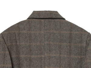 Detail shot of tweed herringbone blazer collar and shoulder structure in taupe plaid