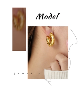 Detail of gold-plated bamboo-style hoop earrings showing twisted texture and glossy finish