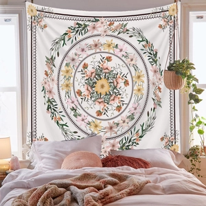 Detailed close-up of a floral mandala tapestry with pink and green accents on a bedroom wall