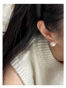 Detail view of pearl stud earring with silver beaded border on model ear