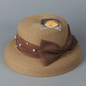 Macro detail of sun hat showing UPF 50+ professional protective label and straw texture