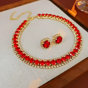Detail view of red square gemstone necklace and earrings on a rustic linen background