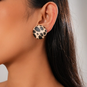 Close-up of leopard print round stud earring worn on model for detail view