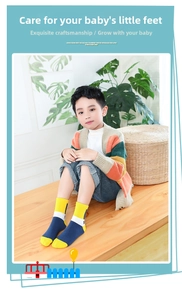 Detail von Kinder-Baumwollsocken mit Farblock-Design und Zifferndruck auf Holzbank