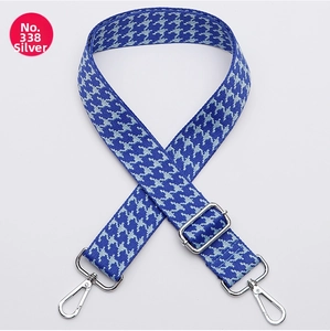 Detail of wide blue houndstooth strap with silver metal swivel hooks and buckles