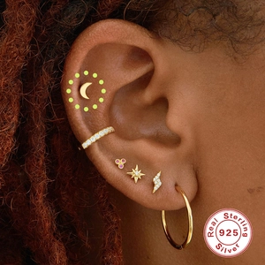 Detail view of S925 sterling silver gold earrings set with moon and star piercing studs