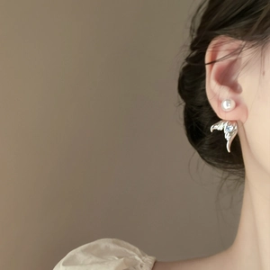 Detail of mermaid style earring with white pearl and blue zircon on a female model
