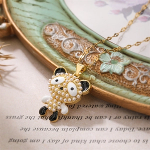Detailed view of a gold panda pendant with pearls and black white enamel on a necklace