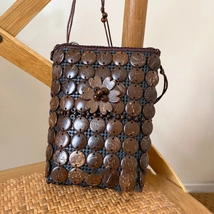 Close-up of bohemian coconut shell floral crossbody bag with handmade woven details