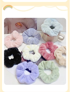 Detailed view of colorful plush furry scrunchies arranged around a white coffee mug