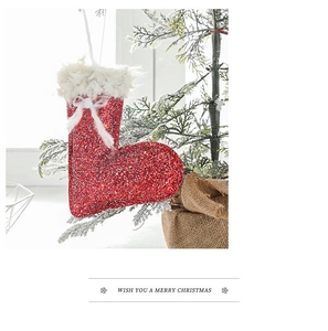 Close-up of a red glitter Christmas stocking ornament with white bow on a festive tree