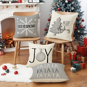 Set of 4 grey Christmas pillow covers with Joy and Merry Christmas prints in a cozy room