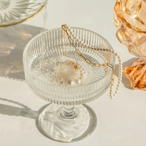 18k gold stainless steel necklace with graduated pearls on a clear glass rim