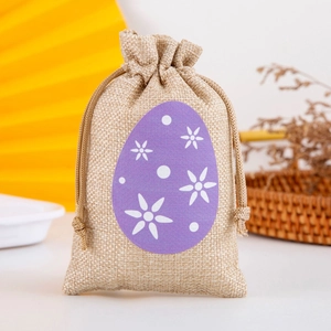 Close-up of beige linen drawstring gift bag with purple floral egg patch detail