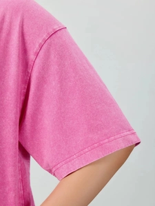 Close-up of pink washed cotton t-shirt showing shoulder seams and cuff stitching details