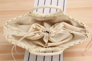Detailed top view of beige woven tote bag with drawstring lining and large capacity