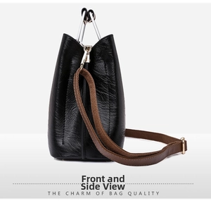 Close-up of black PU leather bucket bag with silver V-shaped handle and textured finish