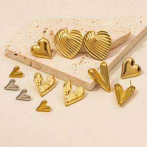Detail of 18K gold and silver heart earrings with textured finish on stones