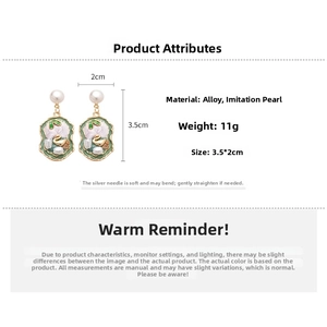 Detail view of pearl pendant earrings with gold floral enamel and 3.5x2cm dimensions