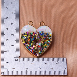Close-up of heart-shaped glitter pendant with gold metal edges on silk fabric