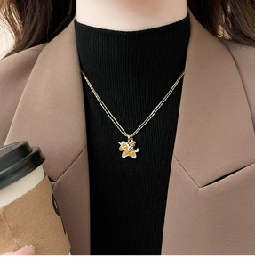 Close-up of elegant gold unicorn necklace with zircon crystals worn by a stylish model