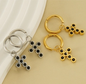 Detail of 18k gold and silver stainless steel hoop earrings with black cross pendants