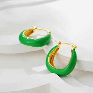 Dettaglio di orecchini a U in oro 18K con smalto verde su supporto geometrico