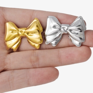 304 stainless steel bow knot stud earrings in gold and silver finish on hand