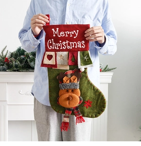 Detail of red and green felt Christmas stocking with 3D reindeer doll and embroidery