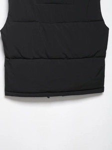 Close-up of black padded vest showing windproof nylon fabric and horizontal quilting