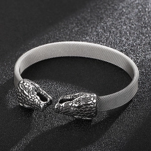 Detailed close-up of a silver stainless steel snake head mesh bracelet on black background
