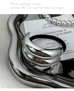 Detail of silver alloy hair tie with sleek crescent metal decor on luxury tray