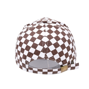 Detail of checkered baseball cap with adjustable bronze metal buckle at the back