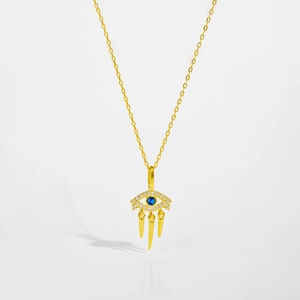 Macro detail of gold S925 silver Evil Eye necklace with blue stone and gold spike pendants