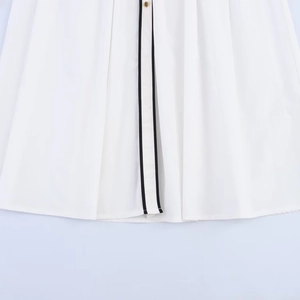 Witte midi-jurk met zwarte contrastbies, gouden knopen en gedetailleerde plissérok