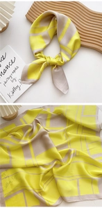 Detail of yellow and beige silk scarf showing satin texture and geometric pattern