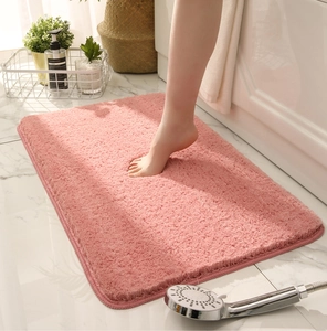 Detail of soft pink thickened plush bath mat with absorbent fibers in a home setting