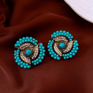 Detail of vintage flower stud earring with turquoise beads and crystals on satin fabric