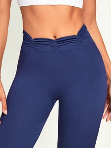 Close-up of navy blue high waist yoga leggings with V-shaped ruched front detail