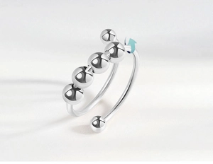 Detail of silver anti-anxiety ring with four rotating beads and adjustable open band