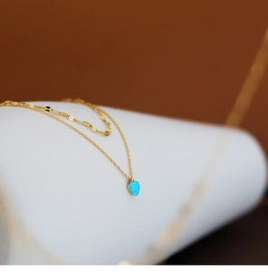 Macro shot of 18K gold-plated double layer necklace with a blue heart-shaped faux opal