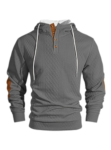 Détail d'un sweat à capuche gris pour homme avec motif en tricot et boutons marrons