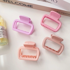 Set of four matte square claw clips in various pink shades on a white surface