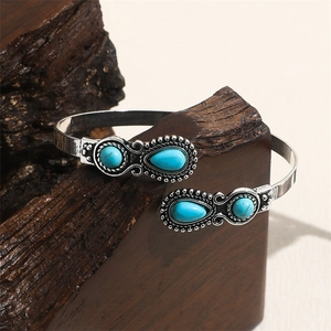 Detailed macro view of vintage silver alloy cuff with turquoise on rustic wood