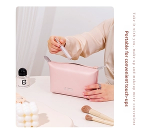 Detail of pink PU leather makeup bag showing hand placing lipstick inside the pouch